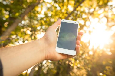 Açık havada cep telefonu kullanan bir adama yaklaş.