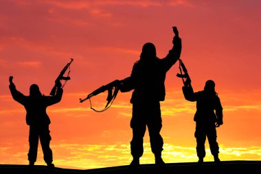 Askeri asker, atış, holding silah, renkli gökyüzü, terörist kavramı silüeti. Tüfek, arka plan üzerinde günbatımı teröristlerle siluet 