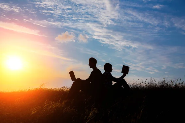 Silueta Hombre Con Portátil Libro Sobre Puesta Del Sol Fondo —  Fotos de Stock