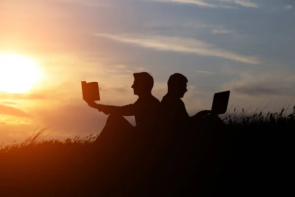 Silueta Hombre Con Portátil Libro Sobre Puesta Del Sol Fondo —  Fotos de Stock