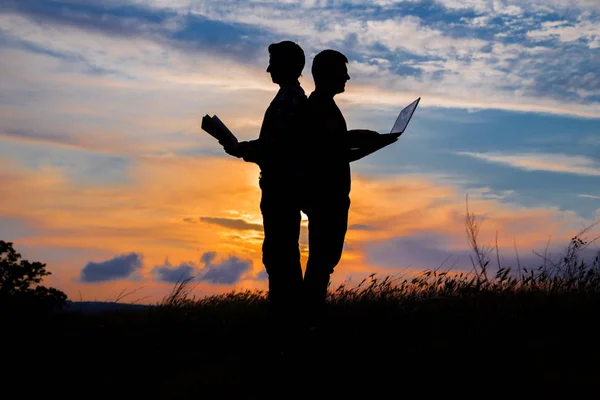 Silueta Hombre Con Portátil Libro Sobre Puesta Del Sol Fondo — Foto de Stock