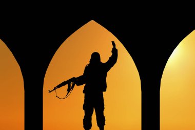 Bir terörist kavramı. Gün batımında tüfek teröristlerle siluet