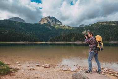 Kara Göl, Durmitor Ulusal Parkı, Zabljak, Karadağ 'a bakan genç adam. Hipster gezgini Kara Göl manzarasının keyfini çıkarıyor