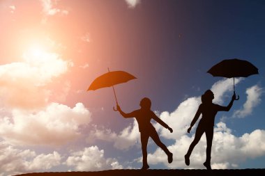 iki kız bir güzel gün batımı holding şemsiyesi arka plan üzerine siluet