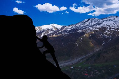 güzel bir gün batımı karşı en yüksek dağlar fethetmek için bir adam silüeti