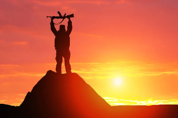 Silhouettenaufnahme Eines Soldaten Mit Gewehr Vor Malerischer Bergkulisse Bei Sonnenuntergang — Stockfoto