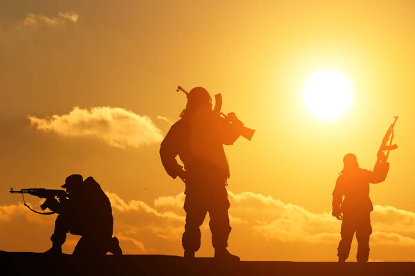 three silhouette of a soldier on a beautiful background