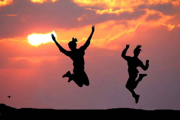 Két Szép Sziluettje Egy Lány Jumping Naplementekor — Stock Fotó
