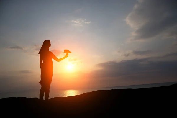 Silhouet Van Een Meisje Bij Zonsondergang Laat Een Papieren Vliegtuig — Stockfoto