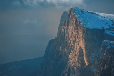 Kış günbatımı kar alan Kırım orman ve tepeler gri gökyüzü altında arka plan üzerinde soğuk çam ağaçları ile dağ yamacı üzerine.