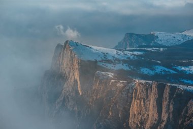 Kış günbatımı kar alan Kırım orman ve tepeler gri gökyüzü altında arka plan üzerinde soğuk çam ağaçları ile dağ yamacı üzerine.