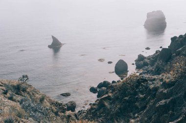 Vahşi deniz kış aylarında. Karanlık bulutlar ve su üstünde ağır sis ile dramatik sahne.