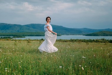 Güzel bir kadın papatya tarlasından zevk alıyor, güzel bir kadın çiçek bahçesinde uzanıyor, güzel bir kız dışarıda dinleniyor, eğleniyor, çiçek tutuyor, mutlu genç bayan ve bahar yeşili doğa, uyum kavramı.