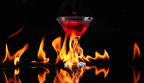 Piment fort dans un verre de martini avec un feu sur fond noir — Photo