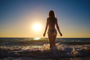 sunset beach, eğlenceli, dans, koşma, bohem kıyafeti, indie style, yaz tatili, güneşli, eğlenceli, olumlu ruh hali olan, Romantik, sıçramasına su, siluet, mutlu, fotoğraf tonda ince genç güzel kadın