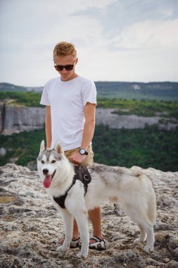 uzun yürüyüşe çıkan kimse ile dağlarda güzel manzaraya bakarak Sibirya husky köpek