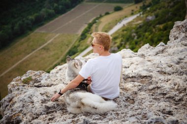 uzun yürüyüşe çıkan kimse ile dağlarda güzel manzaraya bakarak Sibirya husky köpek