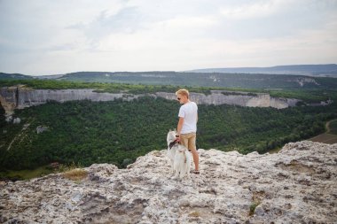 uzun yürüyüşe çıkan kimse ile dağlarda güzel manzaraya bakarak Sibirya husky köpek