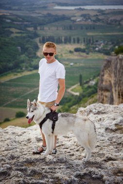 uzun yürüyüşe çıkan kimse ile dağlarda güzel manzaraya bakarak Sibirya husky köpek