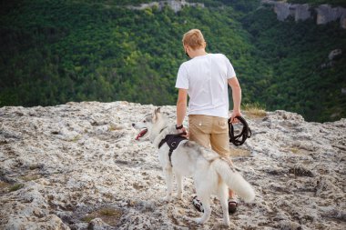 uzun yürüyüşe çıkan kimse ile dağlarda güzel manzaraya bakarak Sibirya husky köpek