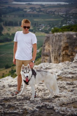uzun yürüyüşe çıkan kimse ile dağlarda güzel manzaraya bakarak Sibirya husky köpek