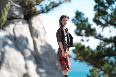 Cliff üzerinde oturan genç kadın ve manzarasının tadını çıkarın. İskoç eteği, İskandinav bir ruh hali içinde bir kız. Kırım'da, Mount kedi