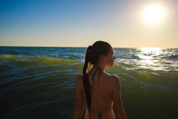 young slim beautiful woman on sunset beach, playful, dancing, running, bohemian outfit, indie style, summer vacation, sunny, having fun, positive mood, romantic, splashing water, silhouette, happy, photo toned