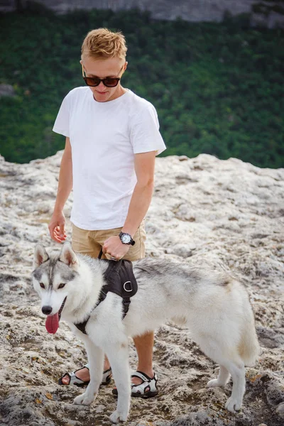 uzun yürüyüşe çıkan kimse ile dağlarda güzel manzaraya bakarak Sibirya husky köpek