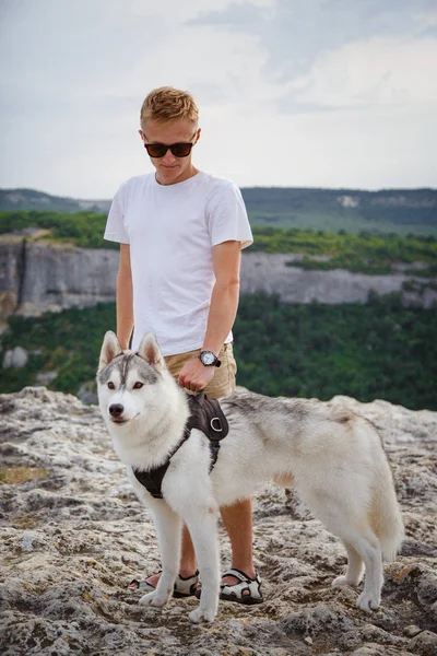 uzun yürüyüşe çıkan kimse ile dağlarda güzel manzaraya bakarak Sibirya husky köpek