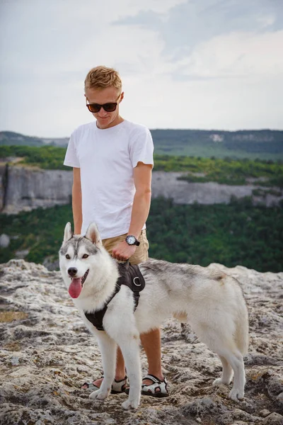 uzun yürüyüşe çıkan kimse ile dağlarda güzel manzaraya bakarak Sibirya husky köpek