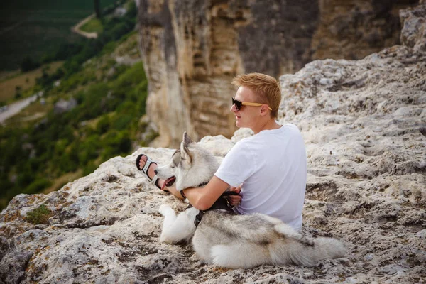 uzun yürüyüşe çıkan kimse ile dağlarda güzel manzaraya bakarak Sibirya husky köpek