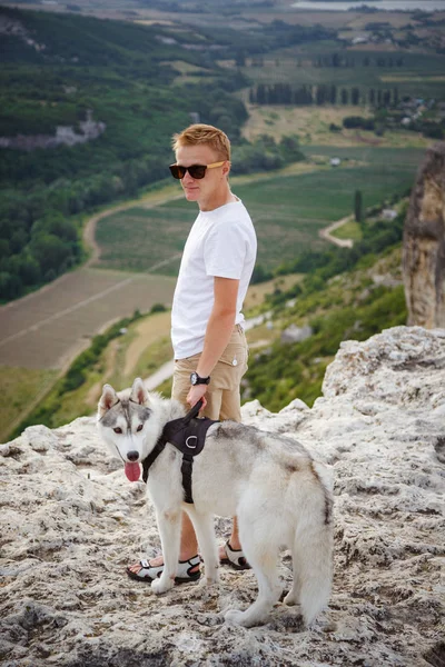 uzun yürüyüşe çıkan kimse ile dağlarda güzel manzaraya bakarak Sibirya husky köpek