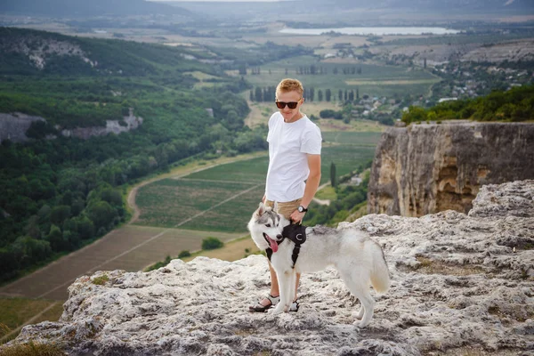 uzun yürüyüşe çıkan kimse ile dağlarda güzel manzaraya bakarak Sibirya husky köpek
