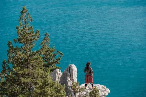 Cliff Üzerinde Oturan Genç Kadın Manzarasının Tadını Çıkarın Skoç Eteği — Stok fotoğraf
