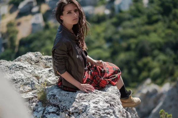 Cliff üzerinde oturan genç kadın ve manzarasının tadını çıkarın. İskoç eteği, İskandinav bir ruh hali içinde bir kız. Kırım'da, Mount kedi
