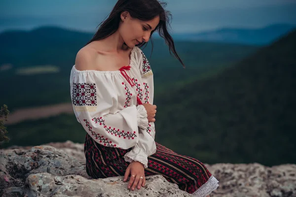 Atractive kadın geleneksel Romen kostüm dağda yeşil arka plan bulanık. Açık fotoğraf. Gelenekler ve kültürel çeşitlilik