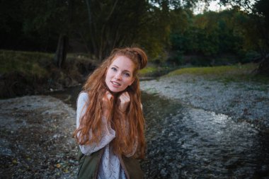 Sonbahar giyim göl kenarında plajda Kızıl saçlı kadın. Genç kadın sonbaharda göl kenarında vakit.