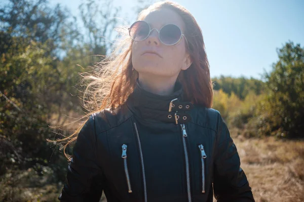 deri ceket sonbahar badem ağaçları ile çevrili olan Dişileştirilmiş kadın