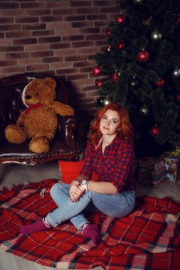 Noel hediyesi. Yeni yıl kutlama. Güzel holdiay Oda ile altında bu hediyeleri Noel ağacı ile dekore edilmiştir. Yeni yıl ve Noel kavramları. Güzel kız yılbaşı ağacının yanında oturan.