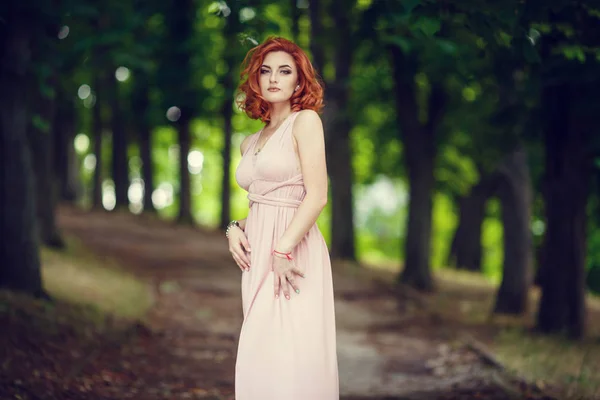 Όμορφη Νεαρή Γυναίκα Ένα Ροζ Φόρεμα Και Κόκκινα Μαλλιά Περιμένοντας — Φωτογραφία Αρχείου
