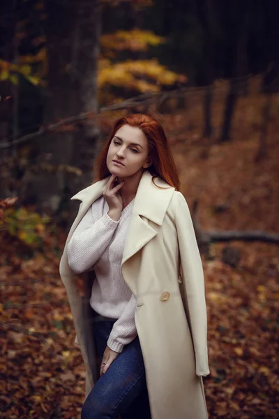 一个美丽的 梦幻般的和悲伤的女孩的肖像在白色大衣秋天的红色头发 — 图库照片