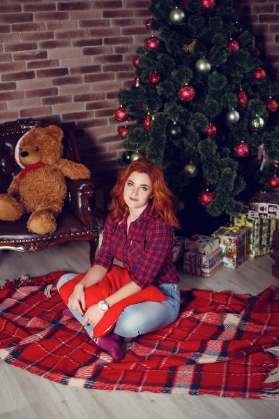 Noel hediyesi. Yeni yıl kutlama. Güzel holdiay Oda ile altında bu hediyeleri Noel ağacı ile dekore edilmiştir. Yeni yıl ve Noel kavramları. Güzel kız yılbaşı ağacının yanında oturan.