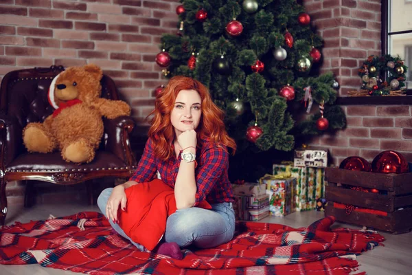 Noel hediyesi. Yeni yıl kutlama. Güzel holdiay Oda ile altında bu hediyeleri Noel ağacı ile dekore edilmiştir. Yeni yıl ve Noel kavramları. Güzel kız yılbaşı ağacının yanında oturan.