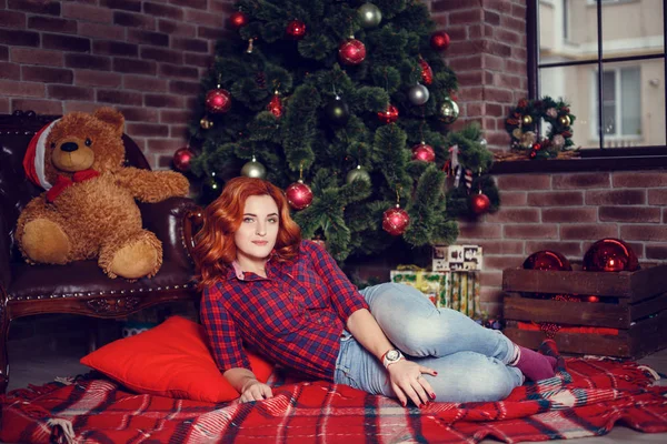 Noel hediyesi. Yeni yıl kutlama. Güzel holdiay Oda ile altında bu hediyeleri Noel ağacı ile dekore edilmiştir. Yeni yıl ve Noel kavramları. Güzel kız yılbaşı ağacının yanında oturan.