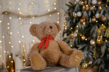 Çeşitli hediyeler ile dekore edilmiş Noel ağacı. Noel ve yeni yıl kutlama. Tatil Noel sahne. Yumuşak oyuncak ayı bir Noel ağacı arka plan üzerinde oturur