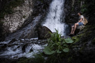 Genç yalınayak turist giyen kot pantolon kısa ve sittin sırt çantası
