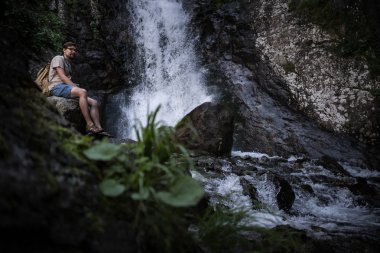 Genç yalınayak turist giyen kot pantolon kısa ve sittin sırt çantası