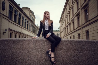 İş takım elbiseli kızıl saçlı bir kız güzel bir eski şehir yürüyor. St.Petersburg