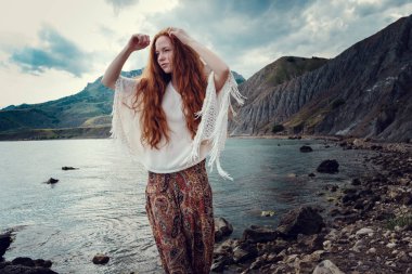 Güneş ışığı altında sahilde poz beyaz tığ işi mayo giyen güzel boho tarz modeli