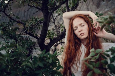 Güneş ışığı altında sahilde poz beyaz tığ işi mayo giyen güzel boho tarz modeli